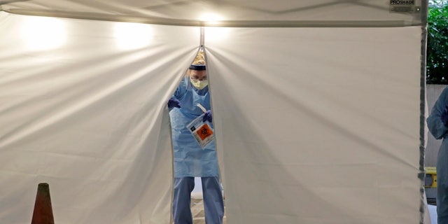 A nurse at a drive up COVID-19 coronavirus testing station in Seattle on March 13. U.S. hospitals are setting up triage tents, calling doctors out of retirement, guarding their supplies of face masks and making plans to cancel elective surgery as they brace for an expected onslaught of coronavirus patients. (AP Photo/Ted S. Warren)