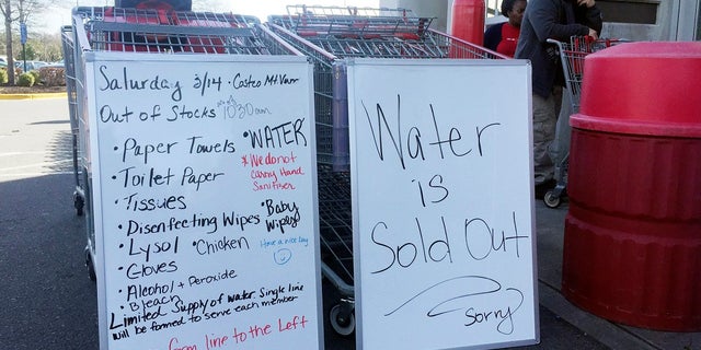 A sign outside a Costco warehouse store in Alexandria, Va., advises shoppers which items have sold out over the weekend. As fears of coronavirus grip the nation, Americans are rushing to stock up on staples and disinfectants. (AP Photo/Kevin S. Vineys)