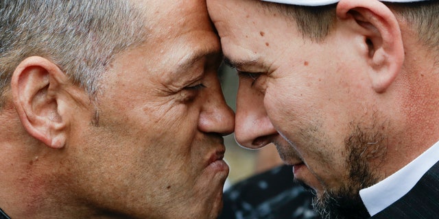Imam of the Al Noor mosque Gamal Fouda, right, and Tu Tangata motorcycle club president Derek Tait exchange a hongi outside the mosque in Christchurch, New Zealand, Sunday, March 15, 2020. A national memorial in New Zealand to commemorate the 51 people who were killed when a gunman attacked two mosques one year ago has been canceled due to fears over the new coronavirus. (AP Photo/Mark Baker)
