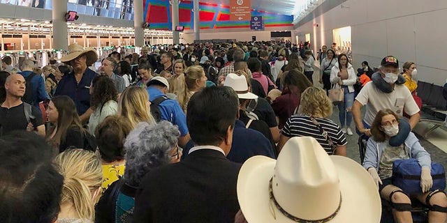 In this photo provided by Austin Boschen, people wait in line to go through the customs at Dallas Fort Worth International Airport in Grapevine, Texas, Saturday, March 14, 2020. International travelers reported long lines at the customs at the airport Saturday as staff took extra precautions to guard against the new coronavirus, The Dallas Morning News reports. Boschen said it took him at least 4 hours to go through the customs. (Austin Boschen via AP)