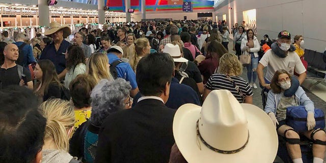 In this photo provided by Austin Boschen, people wait in line to go through the customs at Dallas Fort Worth International Airport in Grapevine, Texas, Saturday, March 14, 2020. International travelers reported long lines at the customs at the airport Saturday as staff took extra precautions to guard against the new coronavirus, The Dallas Morning News reports. Boschen said it took him at least 4 hours to go through the customs. (Austin Boschen via AP)