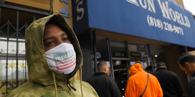 A gun store customer that gave his name only at John waits in line, Sunday, March 15, 2020, in Burbank, Calif. As consumers are buying all kinds of goods in large quantities amid coronavirus concerns, putting pressure on inventories.(AP Photo/Mark J. Terrill)