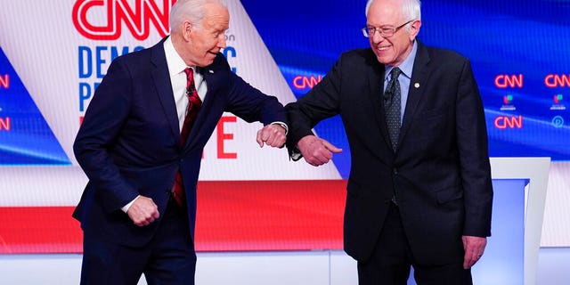 Former Vice President Joe Biden, left, and Sen. Bernie Sanders, I-Vt., right, greet one another before they participate in a Democratic presidential primary debate at CNN Studios in Washington, Sunday, March 15, 2020. (AP Photo/Evan Vucci)