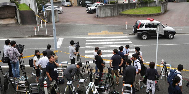 FILE - In this July 26, 2016, file photo, journalists gather in front of Tsukui Yamayuri-en, a facility for the handicapped where a former care home employee killed disabled people, in Sagamihara, outside Tokyo.  (AP Photo/Eugene Hoshiko, File)