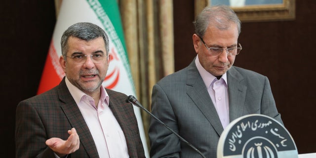 FILE — In this Feb. 24, 2020 file photo, released by the official website of the office of the Iranian Presidency, the head of Iran's counter-coronavirus task force, Iraj Harirchi, left, speaks at a press briefing with government spokesman Ali Rabiei, in Tehran, Iran.  (Iranian Presidency Office via AP, File)