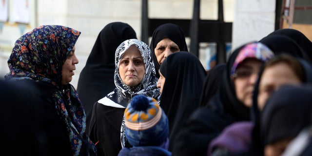 FILE — In this Feb. 21, 2020 file photo, Iranians line up for voting in the parliamentary elections at a polling station in Tehran, Iran. Nine out of 10 cases of the virus in the Middle East come from the Islamic Republic. (AP Photo/Vahid Salemi, File)