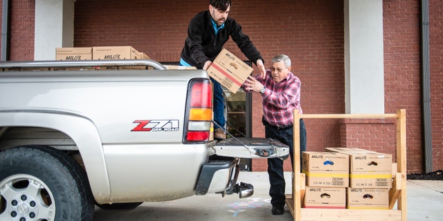 Josh Howard, left, and Ken Runager load boxes of food to be sent to Chestnut Grove Elementary at The Church at Stone River on Monday, March 16, 2020, in Decatur, Ala. Several area schools will be providing food services to students starting Wednesday after students transition to virtual support. (Dan Busey/The Decatur Daily via AP)