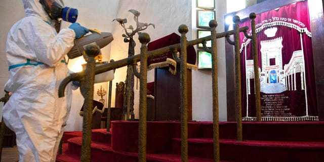 Workers spray disinfectant as a precaution against the coronavirus at the Great Synagogue in Tel Aviv, Israel, Tuesday, March 17, 2020.
