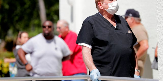 Harold Goodman waits in line to vote in the presidential primary election at the Supervisor of Elections office, Tuesday, March 17, 2020, in Delray Beach, Fla. This polling station was made available after some precincts in Palm Beach County were unable to open after poll workers did not report to work. (AP Photo/Lynne Sladky)