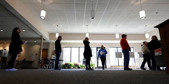 Evanston residents line up for voting at Trinity Lutheran Church in Evanston, Ill., Tuesday, March 17, 2020. Some polling places in Evanston have been moved in an effort to reduce exposure of senior citizens to the COVID-19 coronavirus.(AP Photo/Nam Y. Huh)