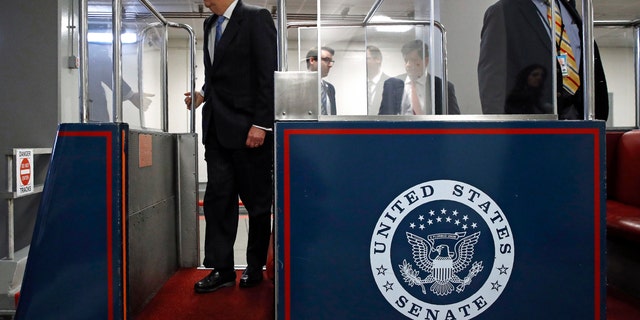 Senate Majority Leader Mitch McConnell of Ky., left, boarding a subway car on Capitol Hill in Washington before a vote on a coronavirus response bill Wednesday. (AP Photo/Patrick Semansky)