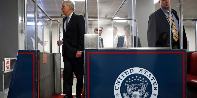 Senate Majority Leader Mitch McConnell of Ky., left, boarding a subway car on Capitol Hill in Washington before a vote on a coronavirus response bill Wednesday. (AP Photo/Patrick Semansky)
