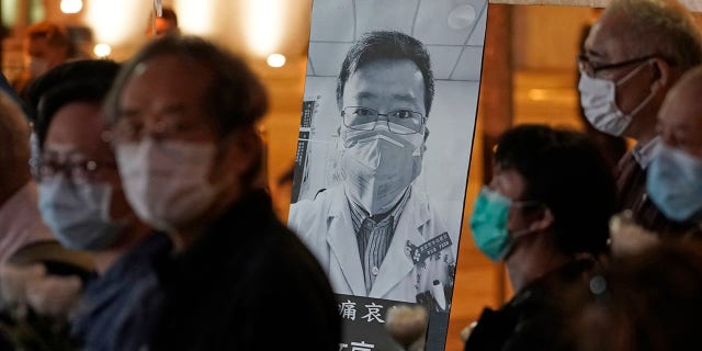 In this Feb. 7, 2020, file photo, people wearing masks attend a vigil for Chinese doctor Li Wenliang, who was reprimanded for warning about the outbreak of the new coronavirus, in Hong Kong. 