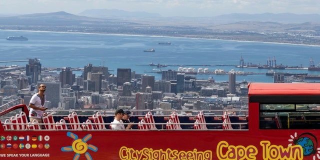 An open-air double decker sightseeing bus, which is virtually empty, stops on the slopes of Table Mountain, overlooking the city of Cape Town, South Africa, Friday March, 20, 2020, as plans are in place to prevent the spread of the coronavirus. For most people the virus causes mild or moderate symptoms, but for others it causes severe illness. (AP Photo)