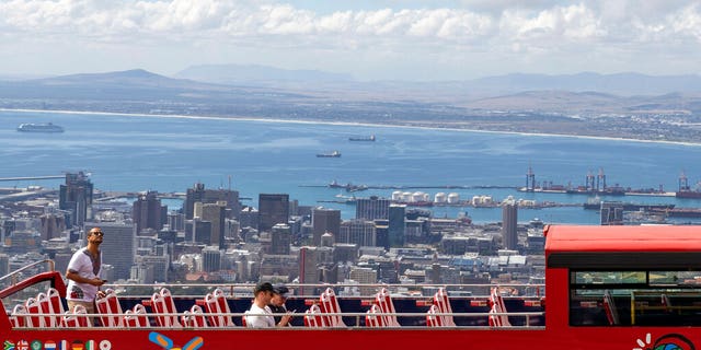 An open-air double decker sightseeing bus stops on the slopes of Table Mountain, overlooking Cape Town, South Africa Friday. (AP Photo)