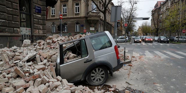 A car is crushed by falling debris after an earthquake in Zagreb, Croatia, Sunday, March 22, 2020. A strong earthquake shook Croatia and its capital on Sunday, causing widespread damage and panic. (Associated Press)