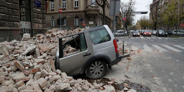 A car is crushed by falling debris after an earthquake in Zagreb, Croatia, Sunday, March 22, 2020. A strong earthquake shook Croatia and its capital on Sunday, causing widespread damage and panic. (Associated Press)