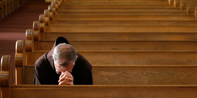 Rev. Micah Muhlen, OFM, prays prior to a modest and shortened service at St. Mary's Roman Catholic Basilica, attended by very few parishioners due to the coronavirus, Sunday, March 22, 2020, in Phoenix. (AP Photo/Ross D. Franklin)