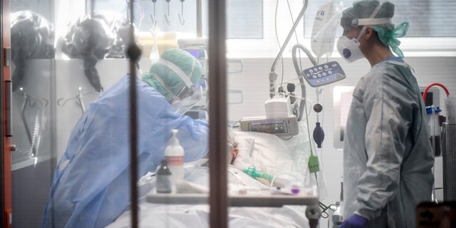 In this Thursday, March 19, 2020, file photo, medical personnel work in the intensive care unit of a hospital in Brescia, Italy. World War II references are now heard daily, not because another momentous 75th anniversary, Victory in Europe Day approaches in May but because of the coronavirus. (Claudio Furlan/LaPresse via AP)