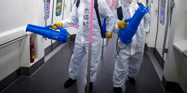 In this March 23, 2020 photo released by Xinhua News Agency, workers disinfect a subway train in preparation for the restoration of public transport in Wuhan, in central China's Hubei province. China's health ministry says Wuhan has now gone several consecutive days without a new infection, showing the effectiveness of draconian travel restrictions that are slowly being relaxed around the country. (Xiao Yijiu/Xinhua via AP)