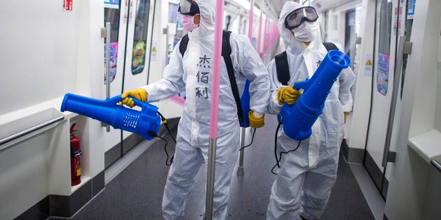 In this March 23, 2020 photo released by Xinhua News Agency, workers disinfect a subway train in preparation for the restoration of public transport in Wuhan, in central China's Hubei province. China's health ministry says Wuhan has now gone several consecutive days without a new infection, showing the effectiveness of draconian travel restrictions that are slowly being relaxed around the country. (Xiao Yijiu/Xinhua via AP)