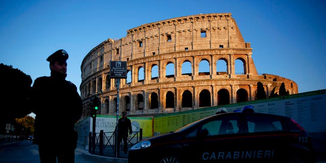 Italian carabinieri patrol Rome's Colosseum at dusk, Monday, March 23, 2020. 
