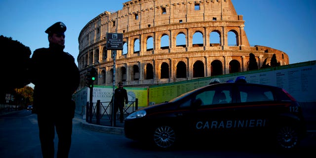 Italian carabinieri patrol Rome's Colosseum at dusk, Monday, March 23, 2020.