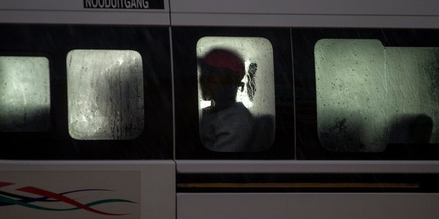 A passenger sits inside a mini-bus taxi in Tembisa, east of Johannesburg, South Africa, Monday, March 23, 2020. South Africa, Africa's most industralized economy and a nation of 57 million people, will to go into a nationwide lockdown for 21 days from Thursday to fight the spread of the new coronavirus. (AP Photo/Themba Hadebe)