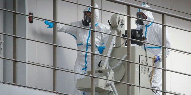 Medical workers move a medical device at the Botkin isolation hospital, where patients are kept in isolation for possible inflection by the new coronavirus, in St.Petersburg, Russia, Tuesday, March 24, 2020, with Russia only reporting a few hundred virus cases. The highly contagious COVID-19 coronavirus can cause mild symptoms, but for some it can cause severe illness including pneumonia.