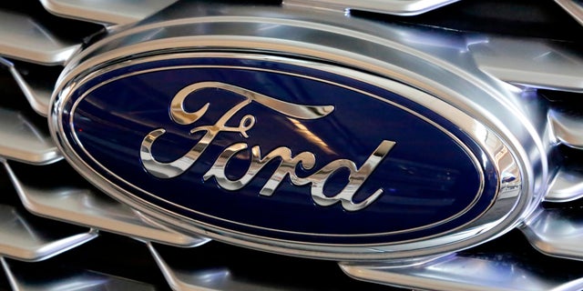 A Ford logo on the grill of a 2018 Ford Explorer on display at the Pittsburgh Auto Show in Feb. 2018. Ford Motor Company has announced plans to make 50,000 ventilators at one of its Michigan plants over the next 100 days in an effort to arm those on the front lines with equipment to fight COVID-19. (AP Photo/Gene J. Puskar, File)