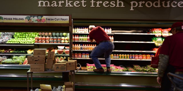Joe Fasula restocks shelves at Gerrity's in Hanover Township, Pa., after suspect Margaret Ann Cirko allegedly coughed on $35,000 worth of produce and meat. (Associated Press)