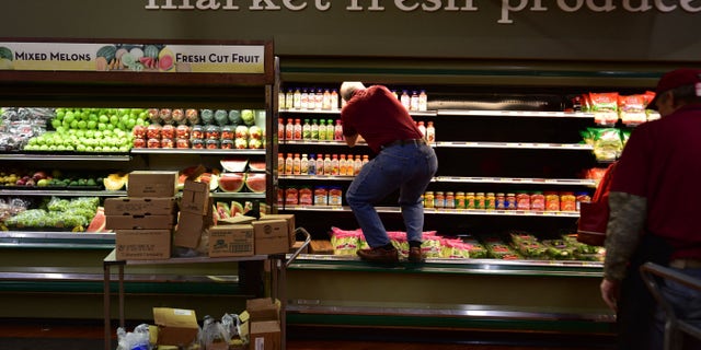 Joe Fasula restocks shelves at Gerrity's in Hanover Township, Pa., after suspect Margaret Ann Cirko allegedly coughed on $35,000 worth of produce and meat. (Associated Press)