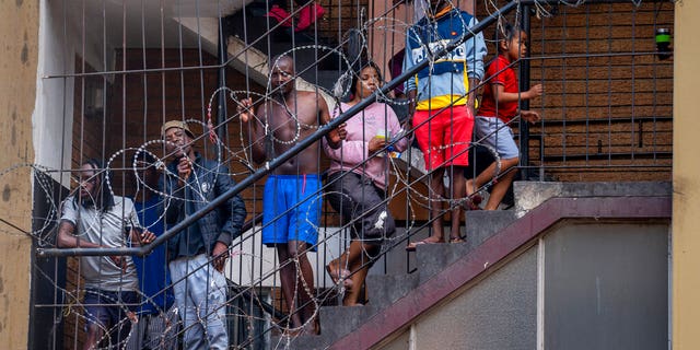 Residents of the densely populated Hillbrow neighborhood of downtown Johannesburg, confined in an attempt to prevent the spread coronavirus, stand on a staircase, Friday, March 27, 2020.