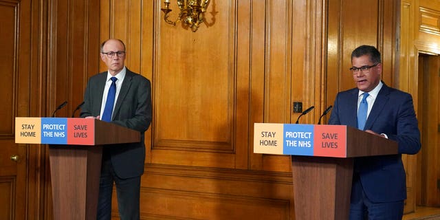 In this image made available by British government because no media allowed into 10 Downing Street because of the coronavirus pandemic, a press coronavirus briefing at Downing Street with Business Secretary Alok Sharma, right, and Medical Director Professor Stephen Powis, during a Digital Press Conference in London, Saturday March 28, 2020.