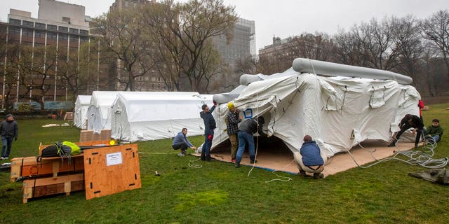 A Samaritan's Purse crew works on building an emergency field hospital equipped with a respiratory unit in New York's Central Park across from the Mount Sinai Hospital in March. (AP Photo/Mary Altaffer)