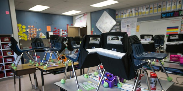 Student's chairs are stacked on top of desks in an empty classroom at closed Robertson Elementary School, March 16, 2020, in Yakima, Wash. (Amanda Ray/Yakima Herald-Republic via AP)