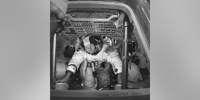 This March 26, 1971 photo made available by NASA shows astronauts Al Worden, center, Dave Scott, left, and Jim Irwin in the Command Module for an altitude chamber test at Cape Canaveral, Fla.
