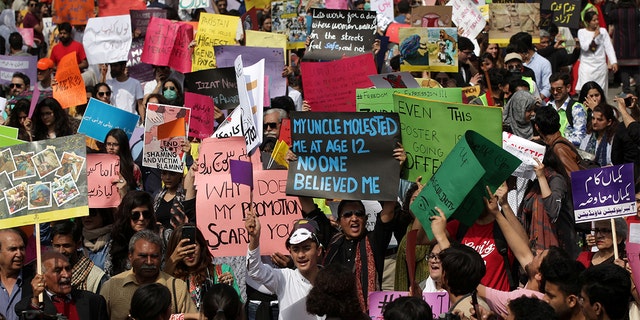 Women and men carry signs as they take part in an Aurat March, or Women's March in Lahore, Pakistan March 8, 2020. REUTERS/Mohsin Raza - RC2QFF9VF0E2