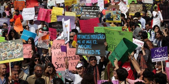 Women and men carry signs as they take part in an Aurat March, or Women's March in Lahore, Pakistan March 8, 2020. REUTERS/Mohsin Raza - RC2QFF9VF0E2