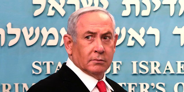 Prime Minister Benjamin Netanyahu approaches the podium to speak from his Jerusalem office on Saturday, March 14, 2020. (Associated Press)