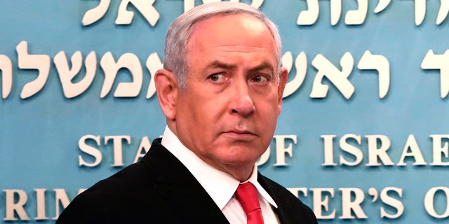 Prime Minister Benjamin Netanyahu approaches the podium to speak from his Jerusalem office on Saturday, March 14, 2020. (Associated Press)