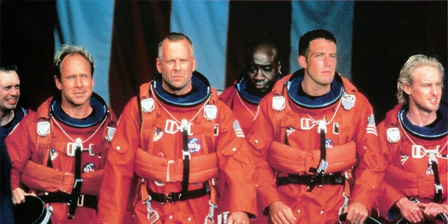 Steve Buscemi, Will Patton, Bruce Willis, Michael Clarke Duncan, Ben Affleck, and Owen Wilson walking in NASA uniforms in a scene from the film 'Armageddon', 1998. Willis' four-decade career has amassed more than $5 billion in box office worldwide.