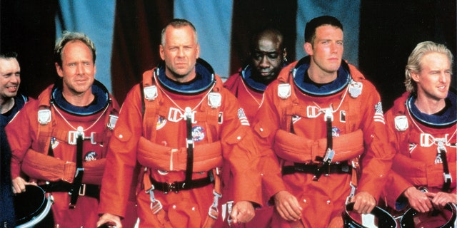 Steve Buscemi, Will Patton, Bruce Willis, Michael Clarke Duncan, Ben Affleck, and Owen Wilson walking in NASA uniforms in a scene from the film 'Armageddon', 1998. Willis' four-decade career has amassed more than $5 billion in box office worldwide.