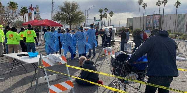 People wait to be screened before entering an homeless shelter set up in a parking lot in Las Vegas on Saturday.