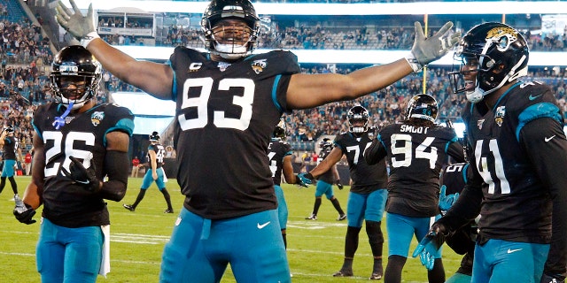 Ex-Jacksonville Jaguars defensive end Calais Campbell (93) celebrates his touchdown against the Indianapolis Colts on a fumble recovery with safety Jarrod Wilson (26) and linebacker Josh Allen (41) during the second half of an NFL football game, in Jacksonville, Fla. On Sunday, March 15, 2020, the Baltimore Ravens agreed to trade a fifth-round draft pick in the upcoming draft to the Jacksonville Jaguars for veteran defensive lineman Calais Campbell. (AP Photo/Stephen B. Morton, File)