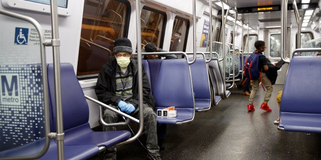 Andre of Washington, D.C., rides the Metro subway Green Line train in Washington, Friday, March, 13, 2020.