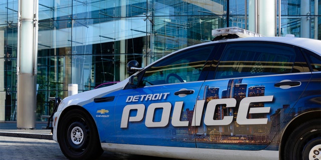 A Detroit Police car parked in front of the Renaissance Center, world headquarters for GM in downtown Detroit.