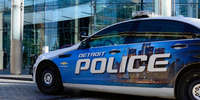 A Detroit Police car parked in front of the Renaissance Center, world headquarters for GM in downtown Detroit.