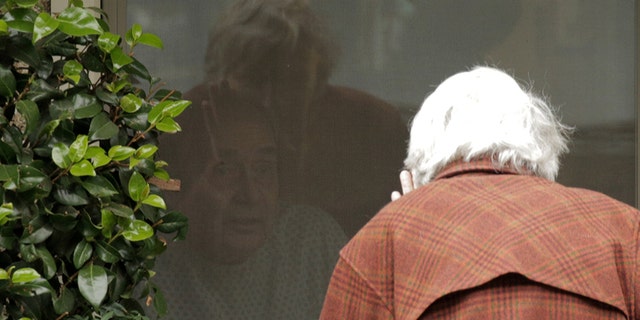 Dorothy Campbell waves while talking through a window to Gene Campbell, her husband of more than 60 years, at the Life Care Center of Kirkland, the long-term care facility linked to several confirmed coronavirus cases in the state, in Kirkland, Washington, U.S. March 5, 2020. 