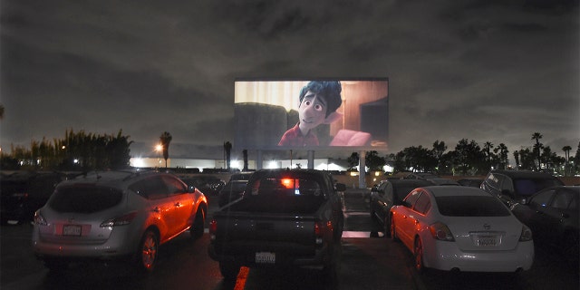 Viewers in parked cars watch the animated film "Onward" at the Paramount Drive-In Theatres, Thursday, March 19, 2020, in Paramount, Calif. The drive-in theater, long a dwindling nostalgia act in a multiplex world, is experiencing a momentary return to prominence. With nearly all of the nation’s movie theaters shuttered due to the pandemic, some drive-in owners think they’re in a unique position to give moviegoers a chance to do something out of the house but stay within prudent distance from one another. (AP Photo/Chris Pizzello)